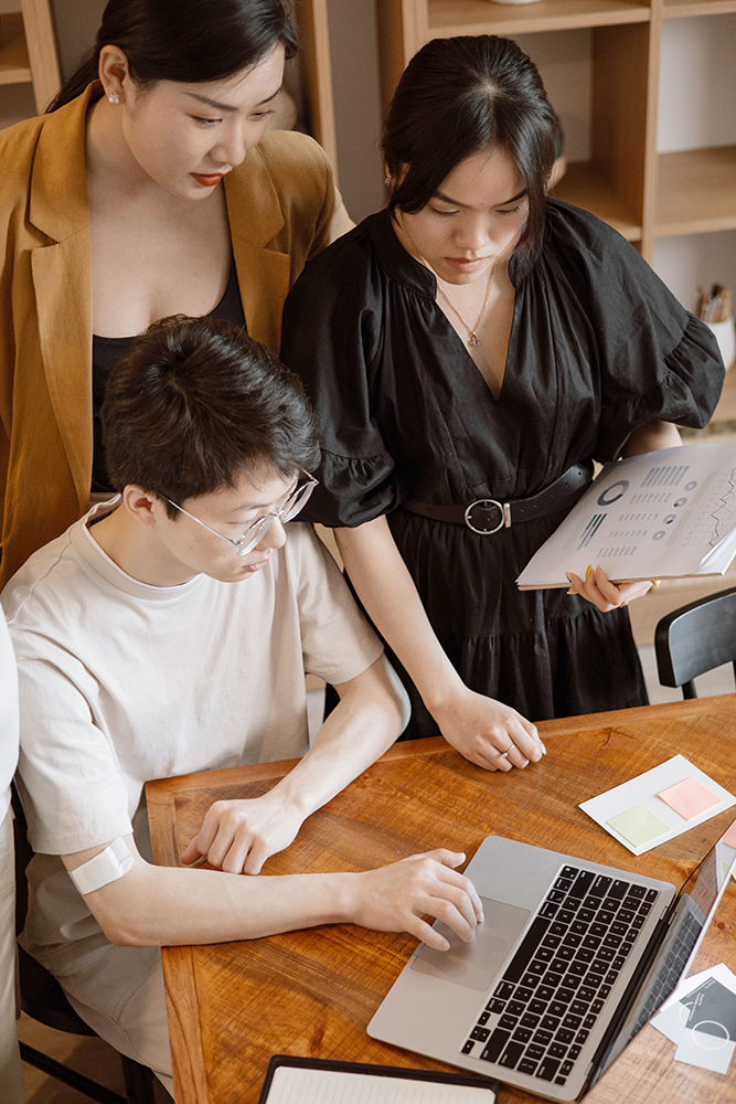 Team collaborating around a laptop